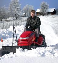 Rasentraktor mit Räumschild im Wintereinsatz